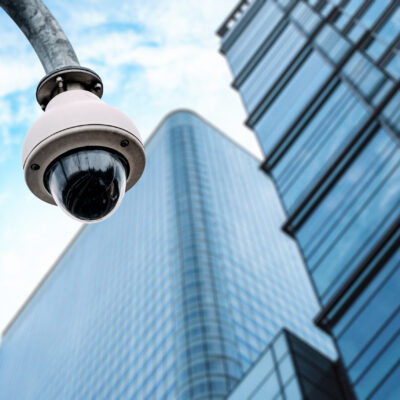 Security camera with a glass building on the background on the street